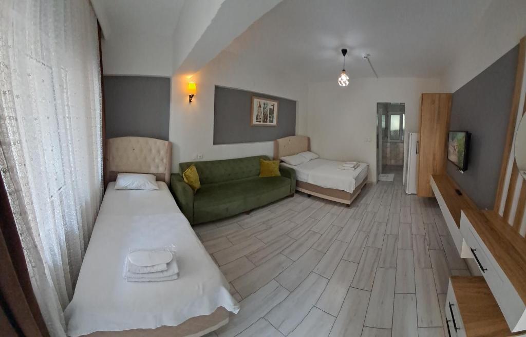 a small room with two beds and a couch at Sun Rose Pansiyon in Pamukkale