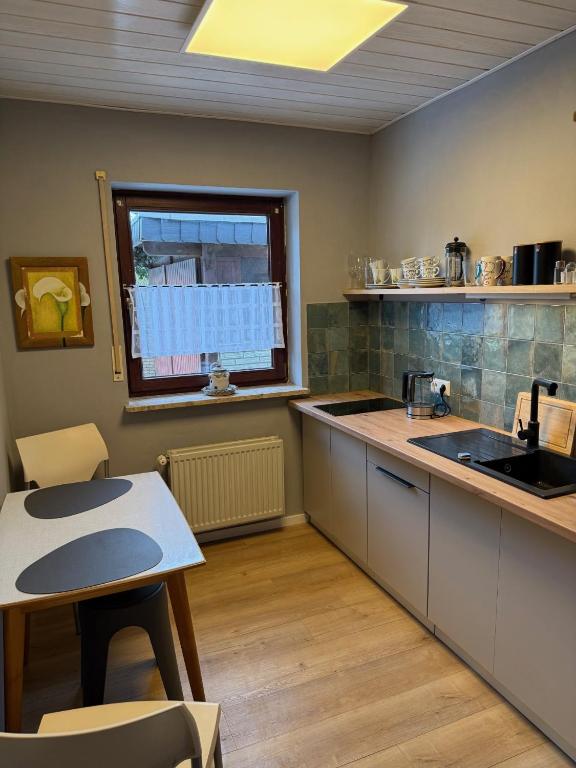 a kitchen with a counter and a table and a window at Schicke kleine Bude (Pretty tiny Flat) in Neuenkirchen