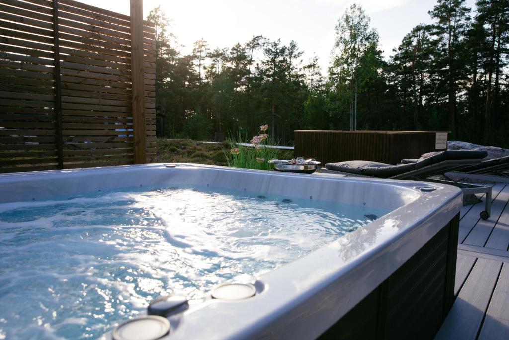 a jacuzzi tub in a backyard with the sun shining at Forest Dream House in Naantali