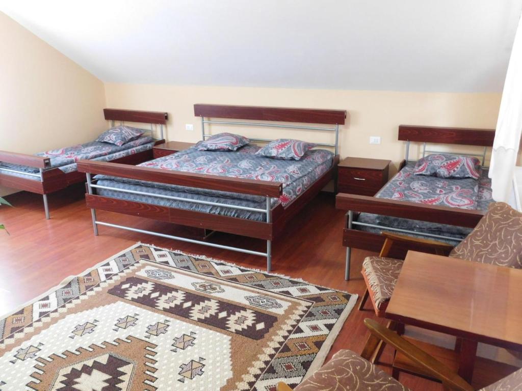 een woonkamer met 3 bedden en een tafel bij Casa Bryanna in Cavnic