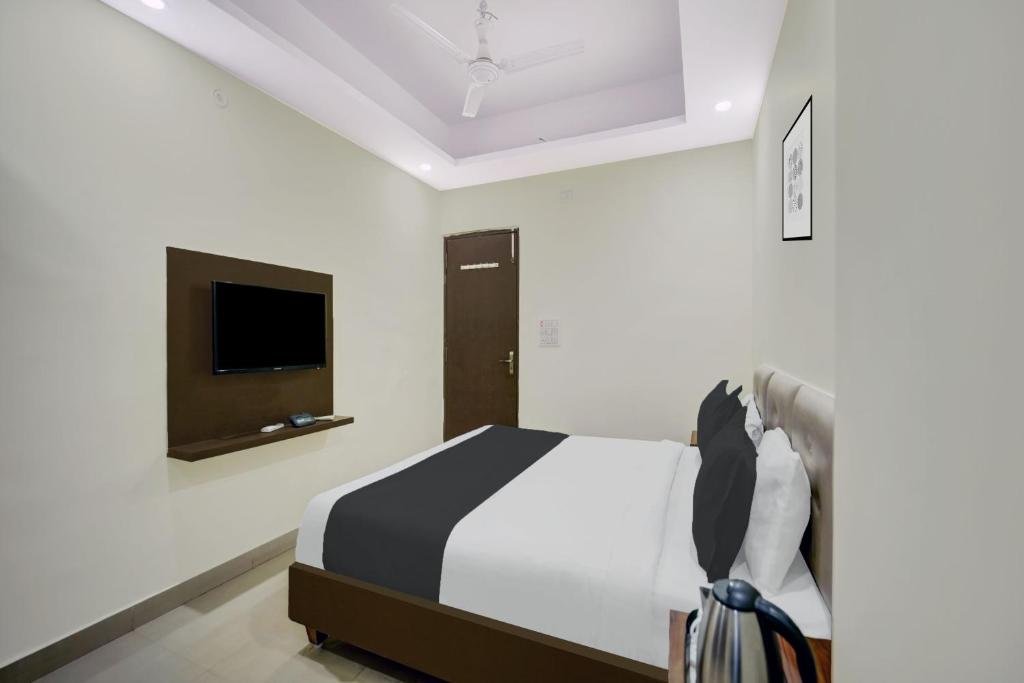 a bedroom with a bed and a flat screen tv at HOTEL O HAPPY PLACE HOTEL & RESORT in Gaya