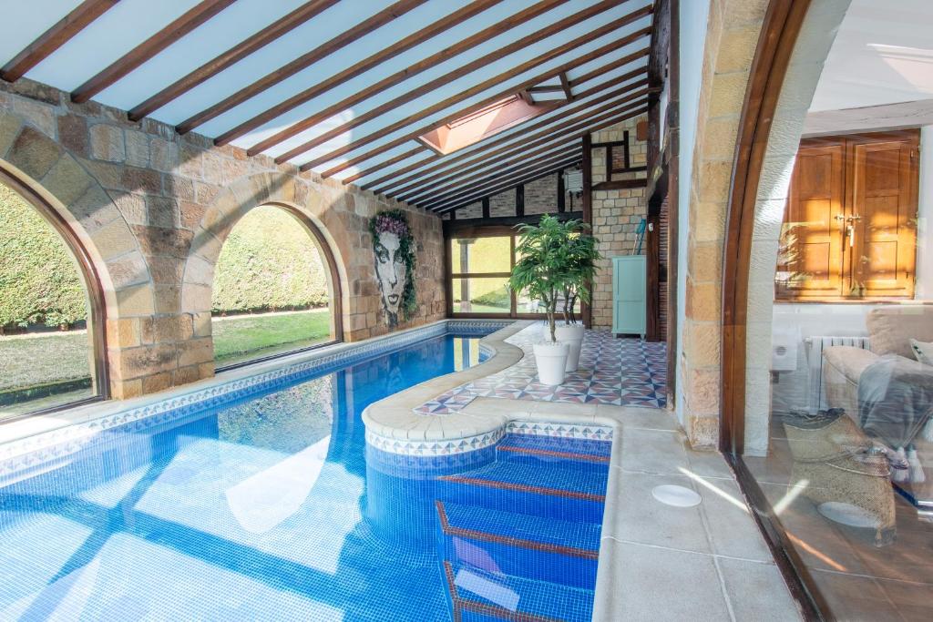 an indoor swimming pool in a house with a swimming pool at Luxury Villa Esmeralda in Suances