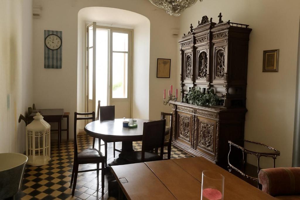 a dining room with a table and a clock on the wall at La vista sul Castello in Cerreto
