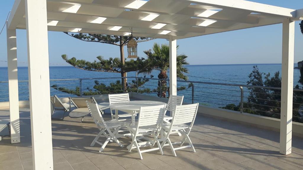 uma mesa e cadeiras num pátio com o oceano em Case Gallina em Avola