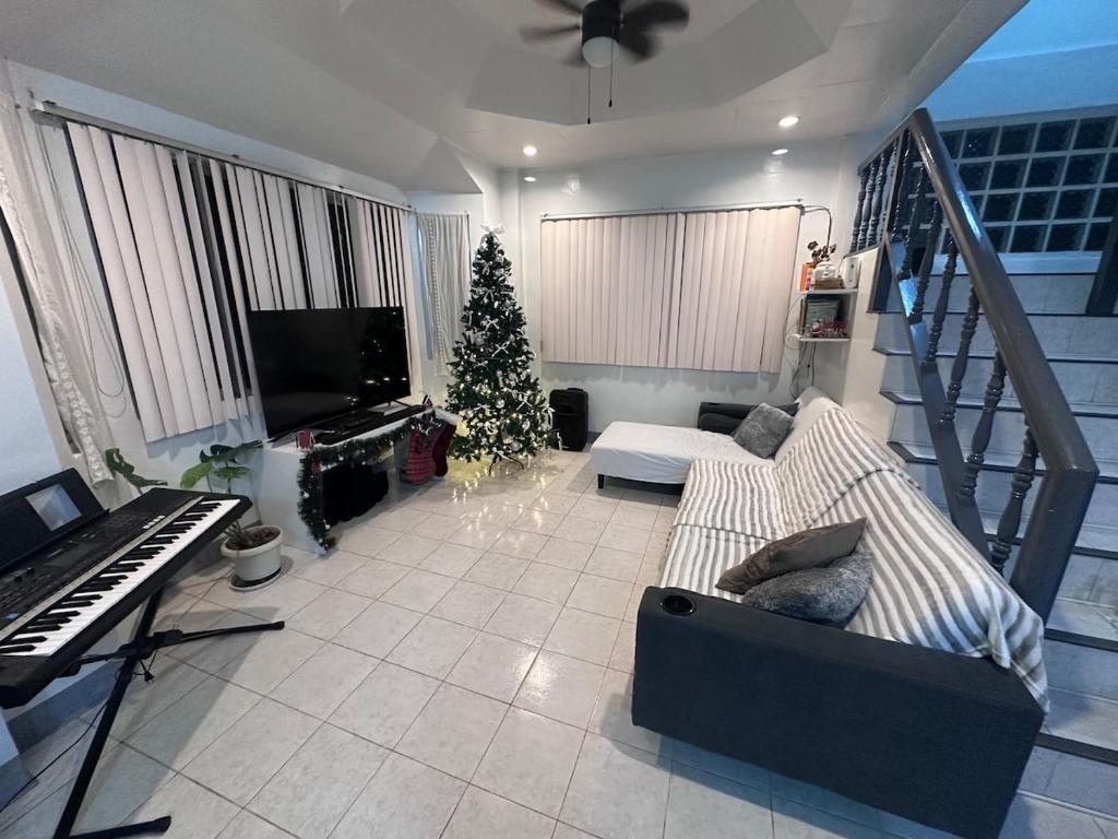 a living room with a christmas tree and a piano at Oslob Cozy Home in Oslob