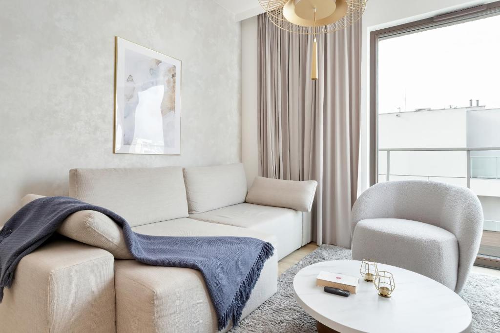 a living room with a couch and a chair and a table at Sol Marina Apartment by Solarento in Wiślinka