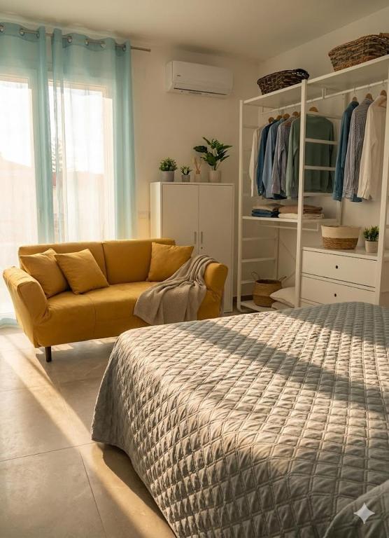 a bedroom with a bed and a yellow couch at Casa Via Marconi in Assemini