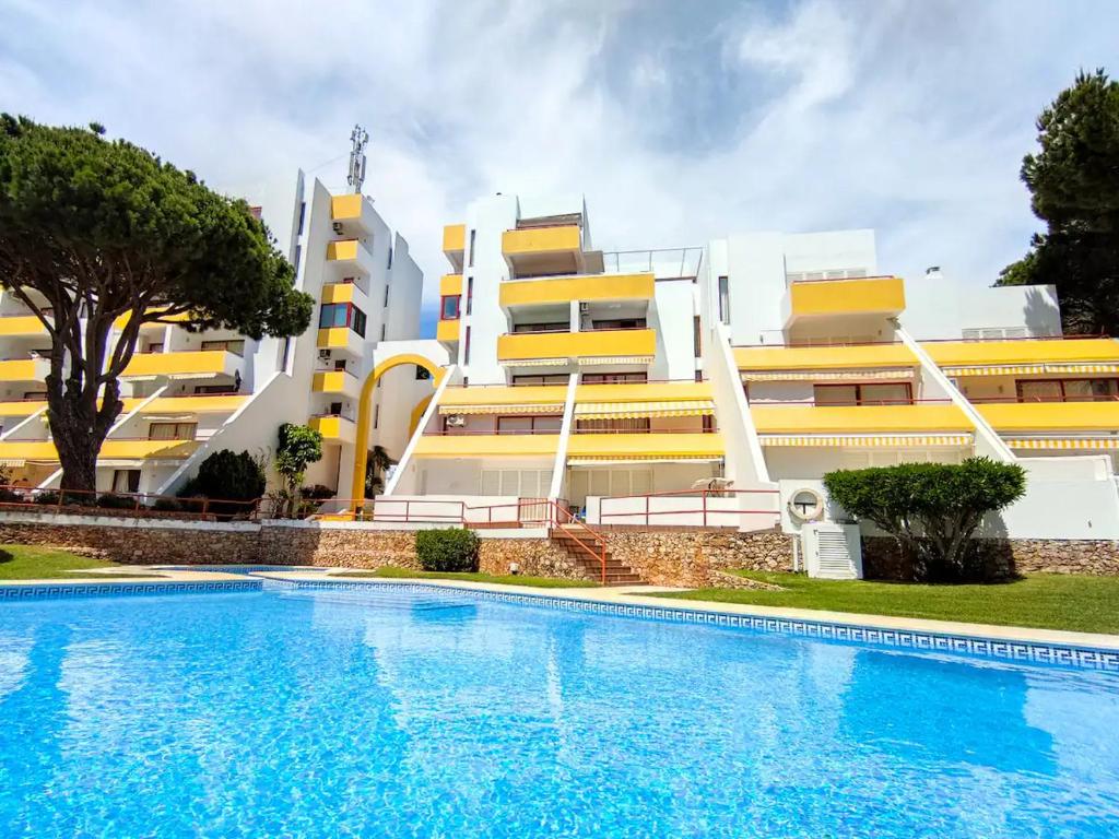 a building with a swimming pool in front of a building at Vilamoura Condo facing the pool by Algarve Dream Holidays in Quarteira