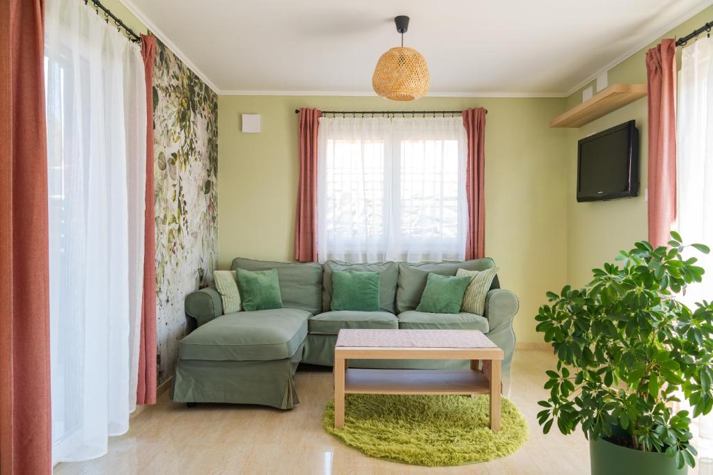 a living room with a green couch and a table at Majoros Garden Apartman in Siófok