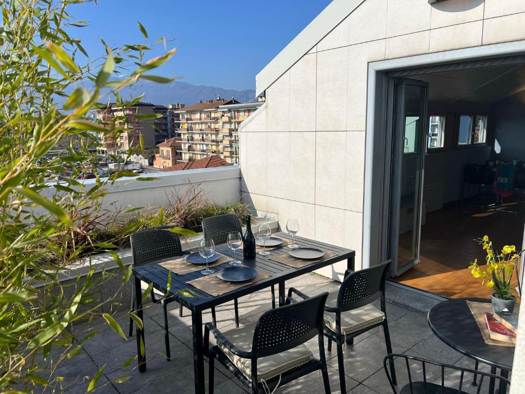 a patio with a table and chairs on a balcony at Attico Don Minzoni in Intra