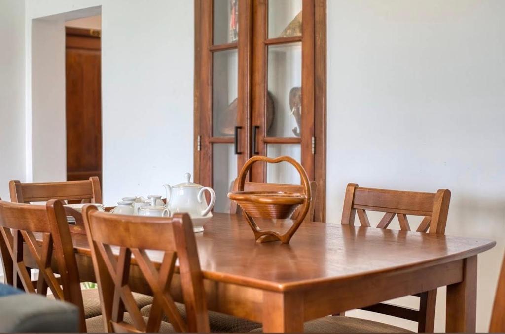 a wooden table with chairs and a wooden basket on top at Emerald Hill Bungalow in Kandy