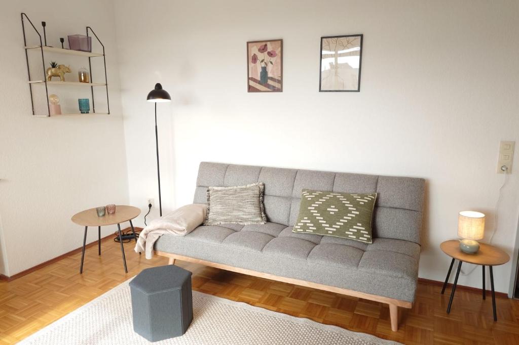 a living room with a gray couch and a table at Wohnen am Klinikum 2 in Oldenburg