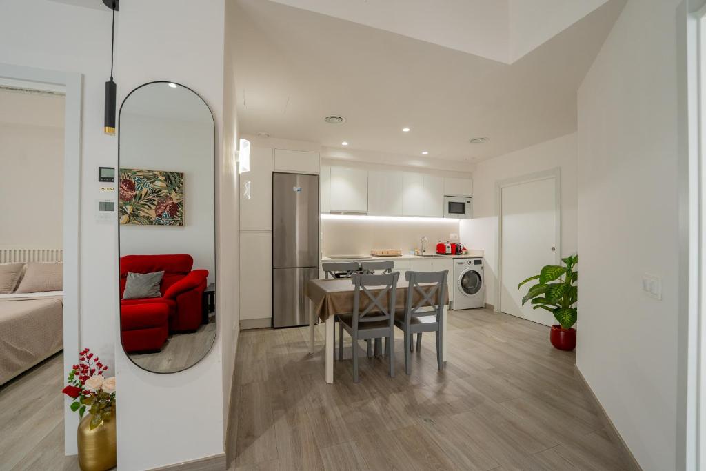 a living room and kitchen with a table and a red couch at Mimi's Apartment in En Corts in Valencia