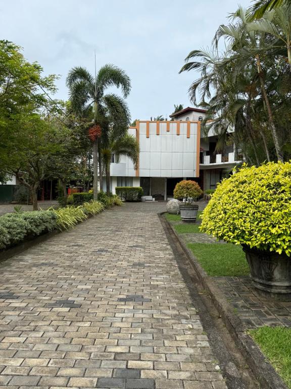 a brick road in front of a building at Hotel Saumya Polhena in Matara
