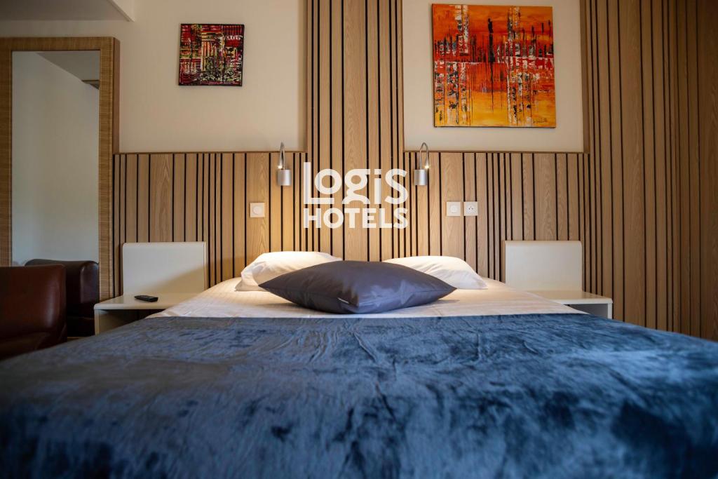 a bedroom with a large bed with a blue blanket at Logis Hôtel Domaine des Trois Pins - anciennement l'Aquitaine in LʼHospitalet