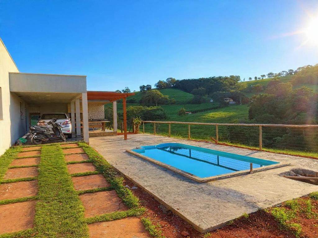 a swimming pool in a yard next to a house at Casa Goulart in Capitólio