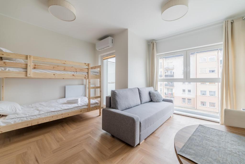 a living room with a bunk bed and a chair at Luboń Urban Nest Studio by BookingHost in Luboń