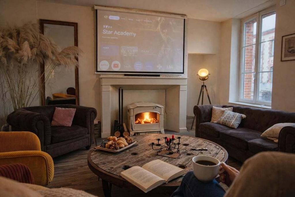a living room with a fireplace and a large screen at Gîte Famille Amis Jeux XXL Paris in Vauchamps
