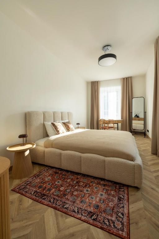 a bedroom with a large bed and a rug at ATRIUM City Center Apartment in Kaunas