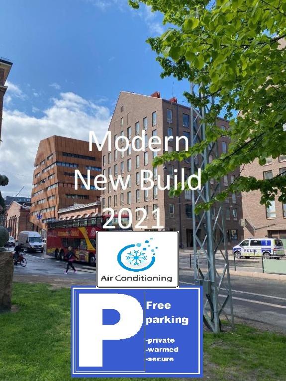 a sign for a modern new building on a city street at Luxury City Seafront Apartment with Balcony in Helsinki