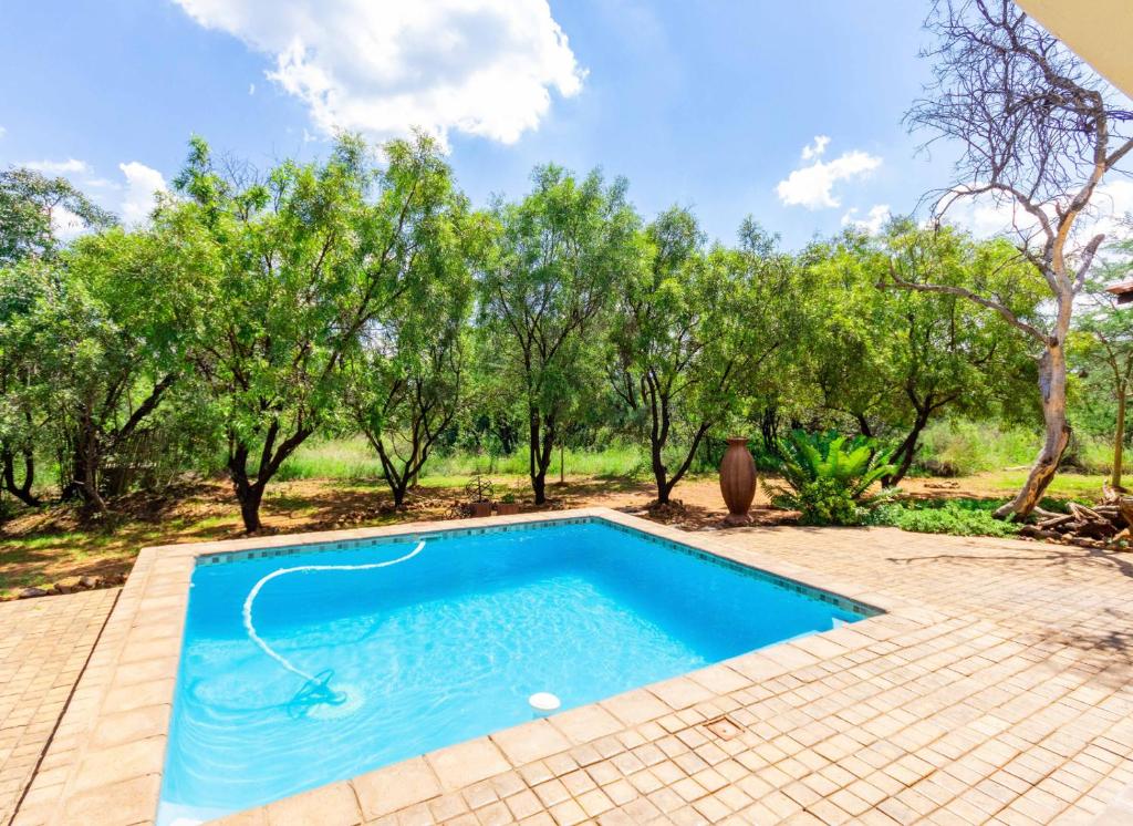 a swimming pool in a yard with trees at Elements Bush Villa 216 in Moheme
