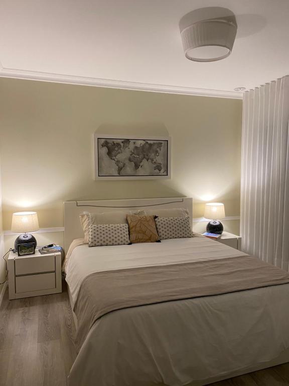 a bedroom with a large bed with two night stands at Modern room (with deck) in Povoação