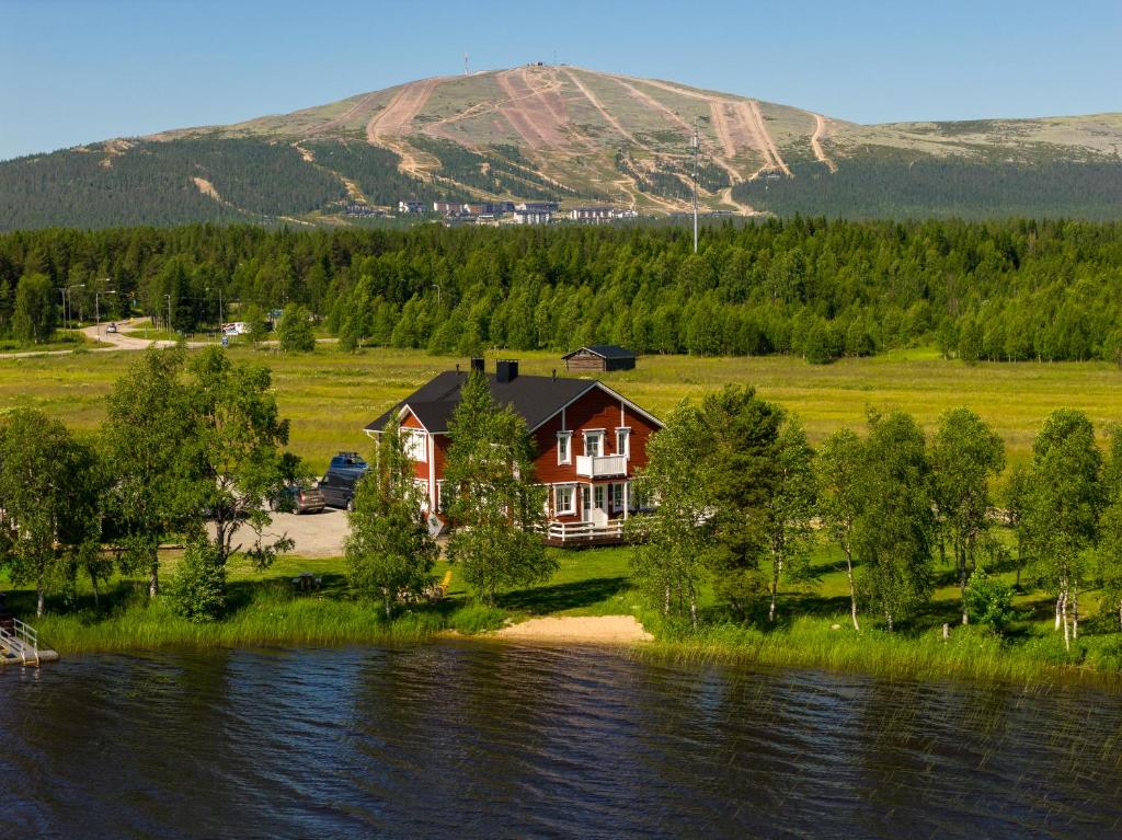 a house on the shore of a body of water at Loimu Resort in Ylläsjärvi