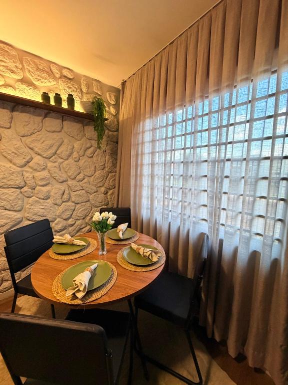 a dining room table with chairs and a window at Apartamento COMPLETO- Próximo ao shopping JL in Cascavel