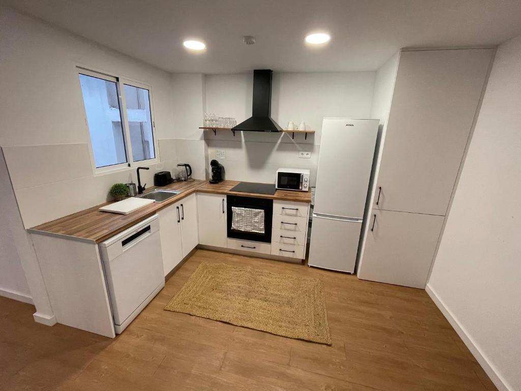 a kitchen with white cabinets and a white refrigerator at Apartamento Pla in Girona