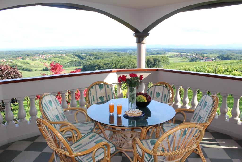 a table and chairs on a balcony with a view at Villa Lotus in Štrigova