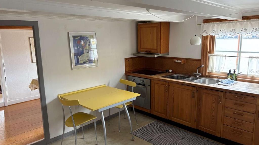 a kitchen with a yellow table and a sink at Válur Cozy Cottage in Válur