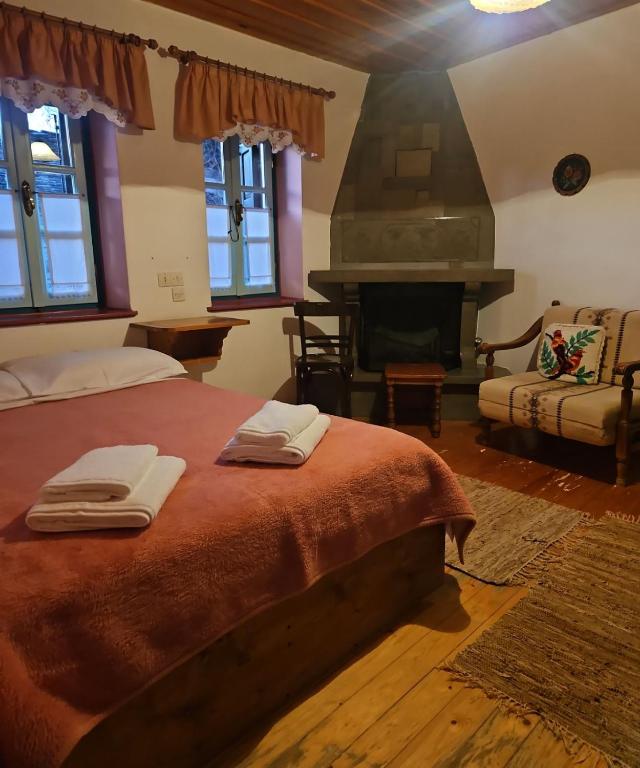 a bedroom with a bed with two towels on it at Βωλίτης Ξενώνας - Παραδοσιακό Καφενείο Ζαγορίου in Papingo