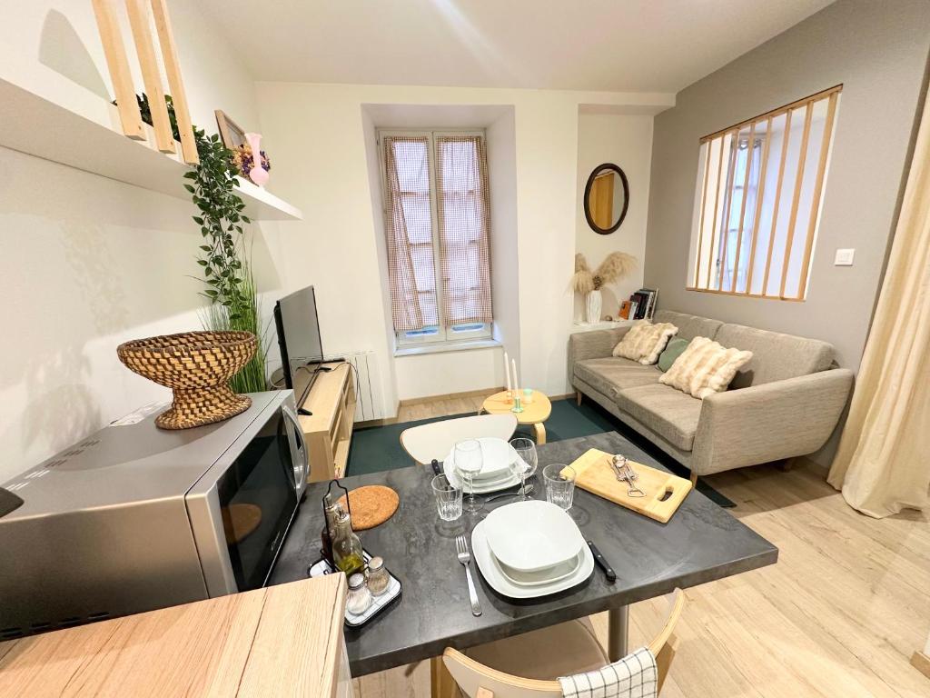 a living room with a table and a couch at Le Cabrol Hyper centre WIFI 1er étage in Rodez