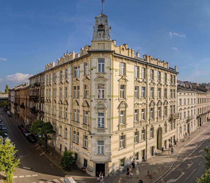 a large yellow building with a tower on top of it at Happy Tower in Krakow