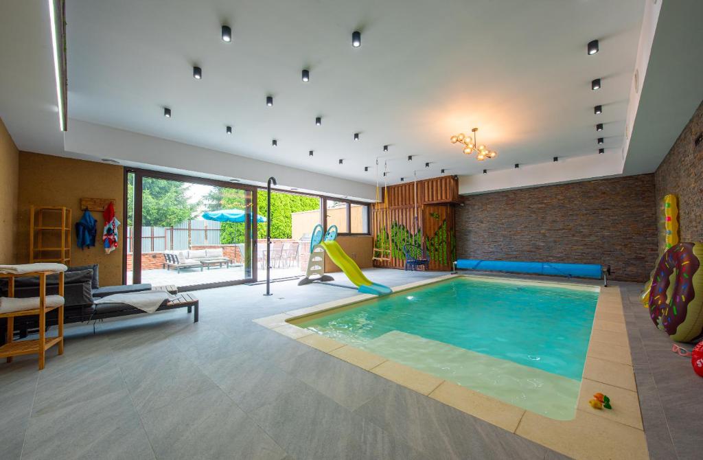 a living room with a swimming pool in a house at Wellness Vila Žakovce s bazénom in Veľká Lomnica