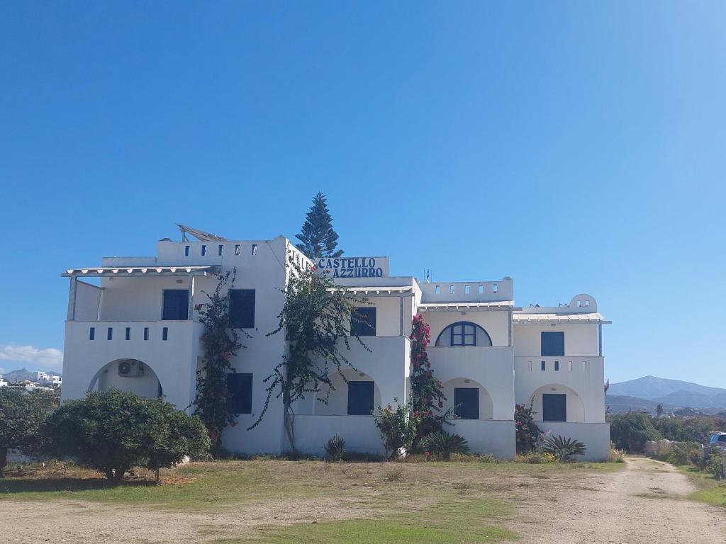 a white house with a blue sky in the background at Castello Azzurro in Agia Anna Naxos