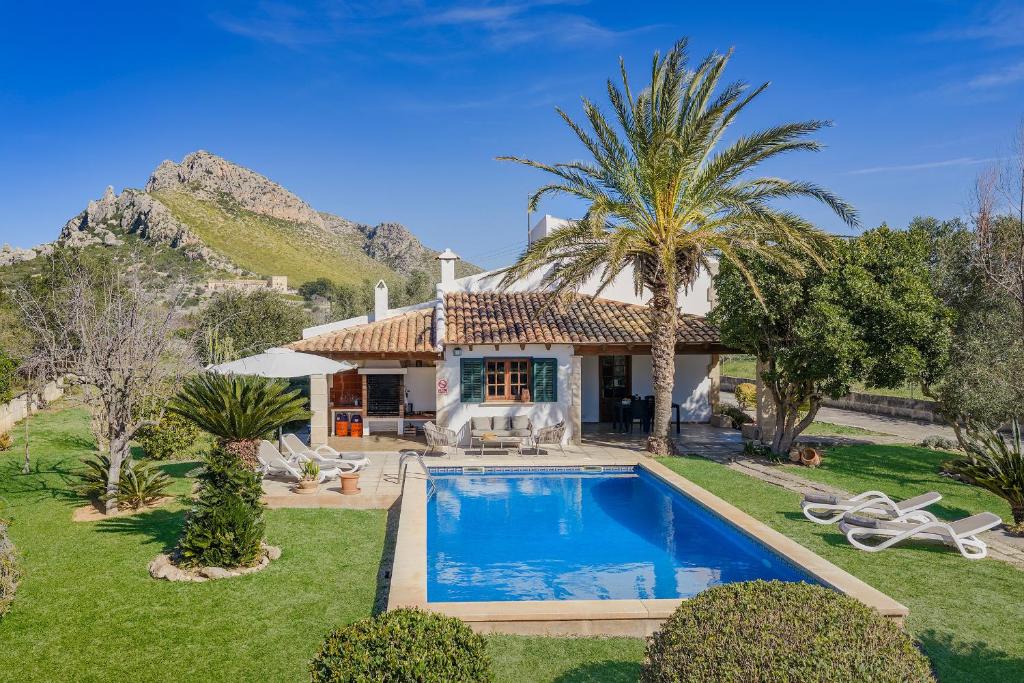 a villa with a swimming pool in front of a house at Villa Can Deyá in Port de Pollensa