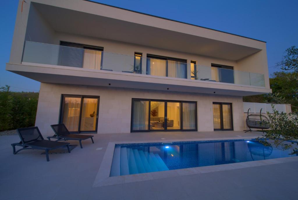 a house with a swimming pool in front of it at Villa Sensei in Linardići
