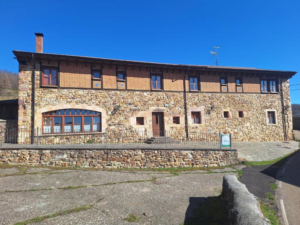 a stone building with a fence in front of it at Oceano verde in Cervera de Pisuerga