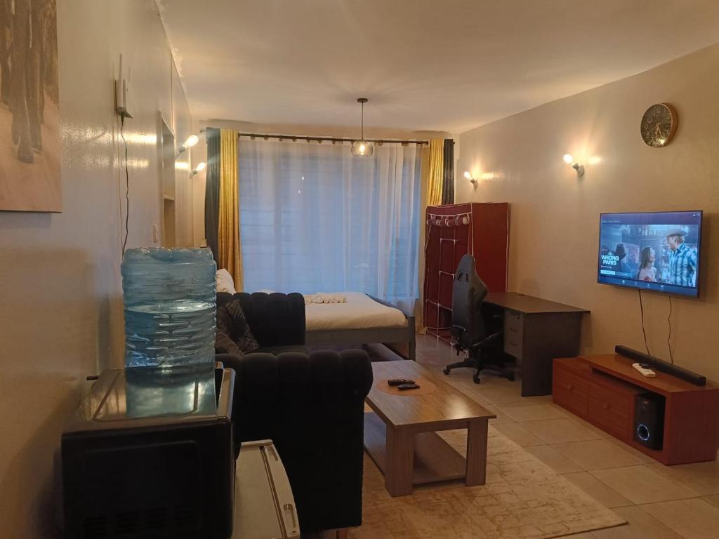 a living room with a couch and a table at Legatus Cozy Studios B - Ongata Rongai Furnished Apartment with Swimming pool in Nairobi