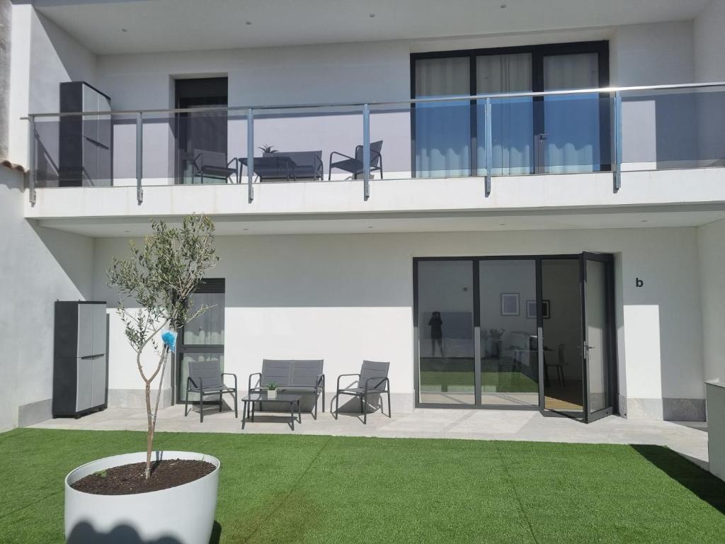a building with a balcony with chairs and a plant at Apartamentos EL FONTANAR in Almagro