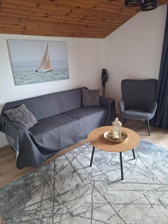 a living room with a couch and a sailboat on the wall at Ferienwohnung Sankt Josef 2 in Bodensdorf