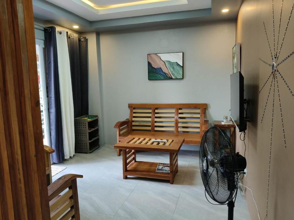 a living room with a table and a fan at MEEK'S VILLAS TRANSIENT HOUSE in Baguio