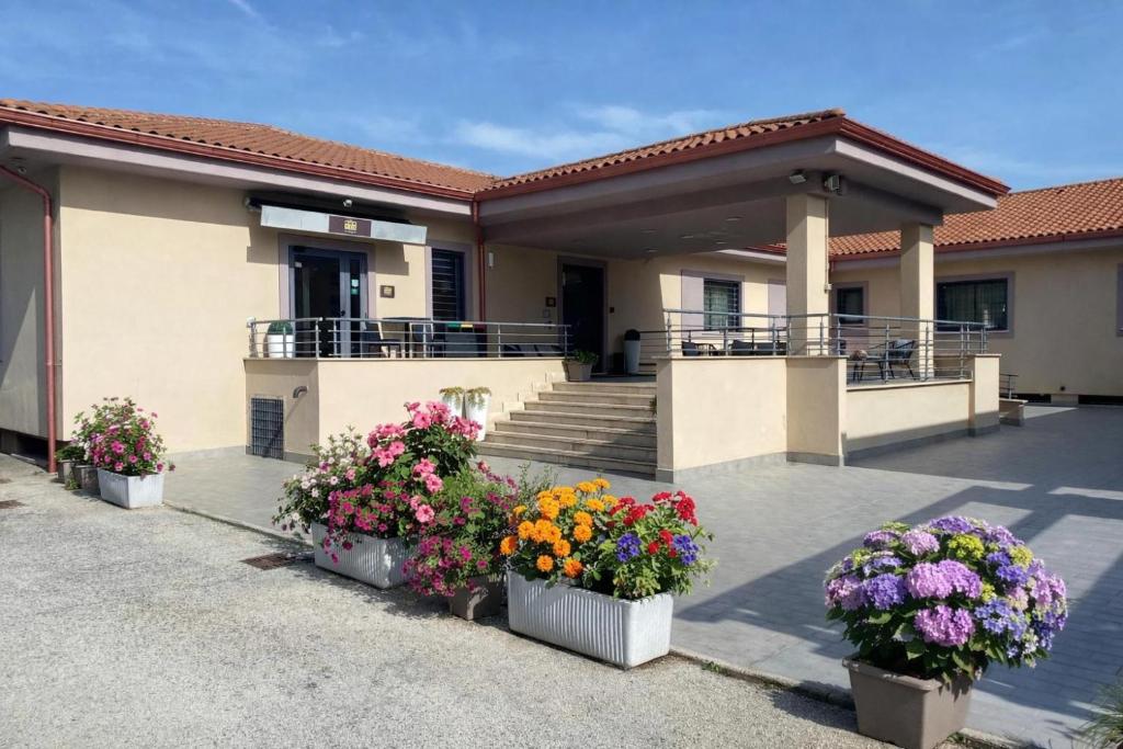 a house with flowers in pots in front of it at Hotel 325 Tor Vergata in Tor Vergata