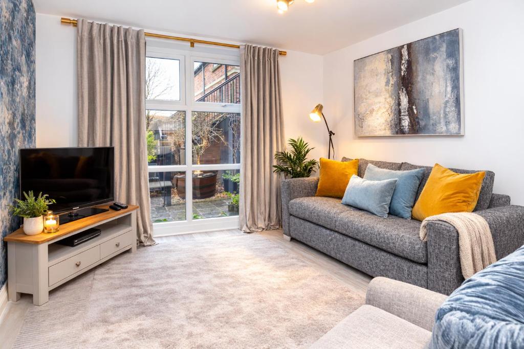 a living room with a couch and a tv at Minster's Reach Apartments -Stylish City-Centre Retreat's in York