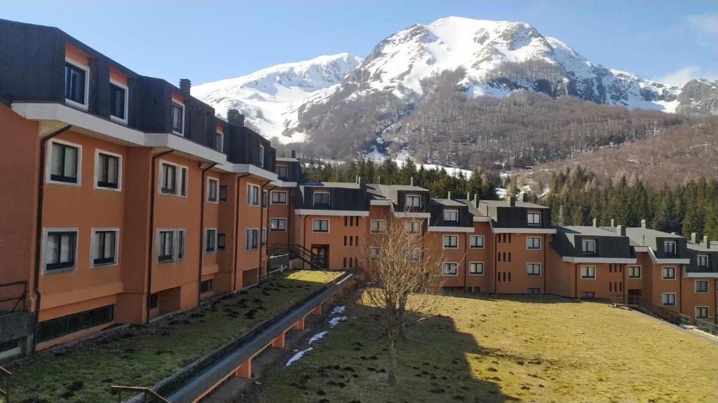 a row of buildings with a snow covered mountain in the background at Sogni di Montagna -Campitello Matese in San Massimo