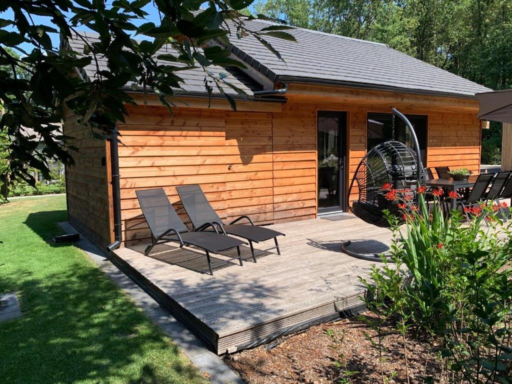 a patio with two chairs and a house at Chalet Liquidambar in Zutendaal