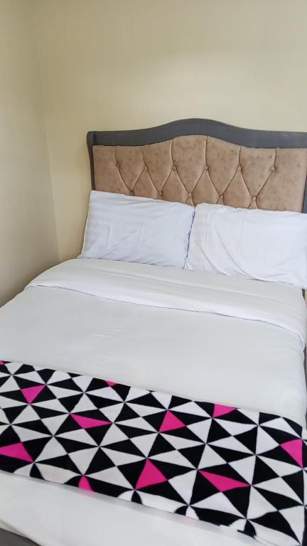 a bed with a black and white checkered blanket at KiQao in Nakuru