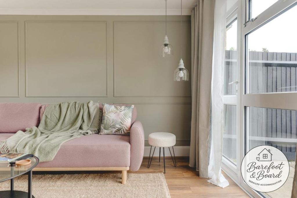 a living room with a pink couch and a window at Luxury 2-Bed House in Stevenage Sleeps 6 Free Parking Barefoot & Board in Shephall