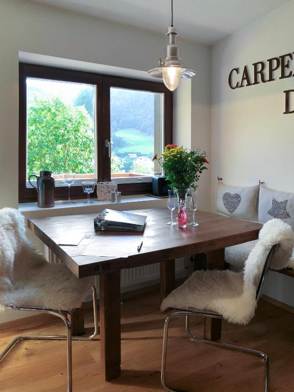 a dining room with a wooden table and two chairs at Bergromantik Ferienwohnung Nesterl mit eigener Sauna und Bergblick in Marktschellenberg